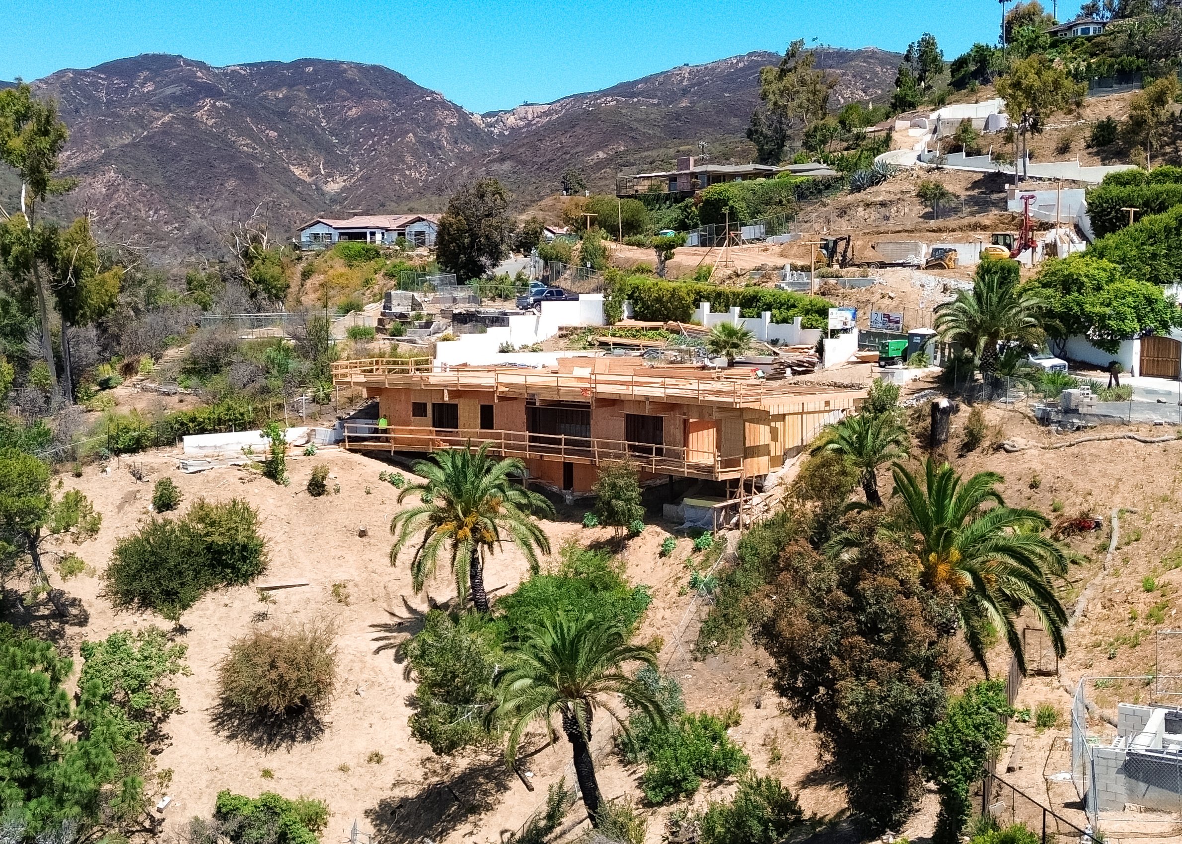 A canyon in the Santa Monica Mountains from the air, homes on the ridges, the coast beyond