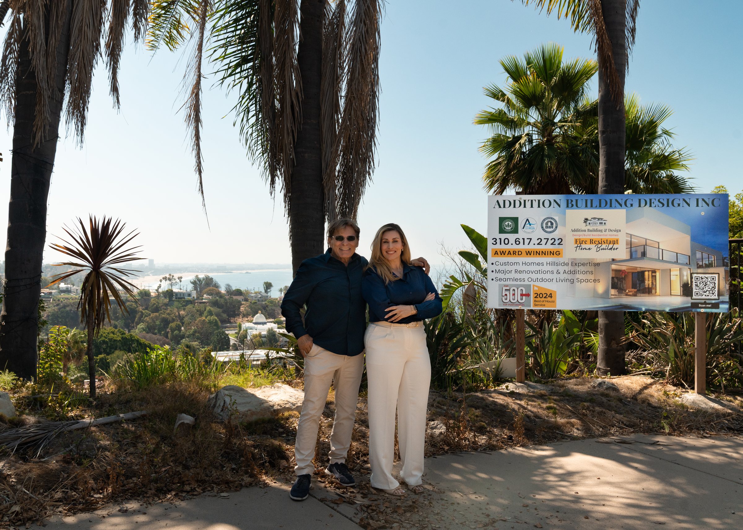 Mike and Christine Ross beside the Addition Building and Design sign at a rebuild site